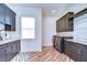 Modern laundry room boasts sleek cabinetry, wood-look tile flooring, and granite countertops at 111 Alafia Estates Ln, Plant City, FL 33567