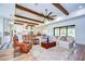 Spacious living room featuring wood beams, large windows, and an open floor plan to the kitchen at 111 Alafia Estates Ln, Plant City, FL 33567