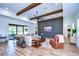 A modern living room with a large wall-mounted television, exposed beams and wood-look tile floors at 111 Alafia Estates Ln, Plant City, FL 33567