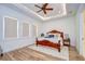 Elegant main bedroom with tray ceiling, plush carpet, and bright windows at 111 Alafia Estates Ln, Plant City, FL 33567
