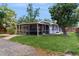 Wide exterior angle of the home and screened patio with a sprawling lawn at 1202 E Caracas St, Tampa, FL 33603