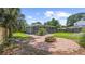 Landscaped backyard with a brick firepit area and a screened-in patio at 1202 E Caracas St, Tampa, FL 33603