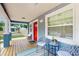 Inviting front porch with ample seating, a vibrant red door, and a view of the surrounding neighborhood at 1202 E Caracas St, Tampa, FL 33603
