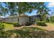 View of the backyard with a screened-in lanai, manicured hedges, and lush green grass at 14817 Tudor Chase Dr, Tampa, FL 33626