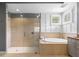 Bathroom with a glass-enclosed shower, a soaking tub, and a window for natural light at 14817 Tudor Chase Dr, Tampa, FL 33626