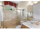 Bright bathroom with a glass shower, vanity, neutral tile, and natural light at 14817 Tudor Chase Dr, Tampa, FL 33626