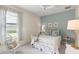 Charming bedroom featuring a white bed, matching white furniture, soft lighting, and a light blue accent wall at 14817 Tudor Chase Dr, Tampa, FL 33626