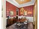 Formal dining room with decorative wallpaper, chandelier, and a large table for elegant dinners at 14817 Tudor Chase Dr, Tampa, FL 33626