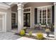 Charming front porch featuring double doors, decorative plants, and stylish seating with a welcoming atmosphere at 14817 Tudor Chase Dr, Tampa, FL 33626