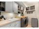 Well-organized laundry room featuring a sink, wood countertop, washer, dryer, and ample storage space at 14817 Tudor Chase Dr, Tampa, FL 33626