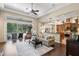 Bright living room with hardwood floors, a large window, comfortable seating, and an open view to the kitchen at 14817 Tudor Chase Dr, Tampa, FL 33626