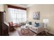 Cozy living room with a sofa, chair, rug, and a large window covered with elegant white curtains at 14817 Tudor Chase Dr, Tampa, FL 33626