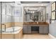 Stylish main bathroom featuring a soaking tub, a large mirror, and a dual sink vanity at 14817 Tudor Chase Dr, Tampa, FL 33626