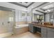 Main bathroom featuring a large mirror, soaking tub, separate shower, and dual sink vanity at 14817 Tudor Chase Dr, Tampa, FL 33626