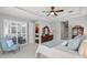 Bright main bedroom with tray ceiling, an accent chair, a dresser, and access to a balcony at 14817 Tudor Chase Dr, Tampa, FL 33626