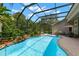 Sparkling pool featuring a waterfall feature, lush landscaping, and a screened enclosure at 14817 Tudor Chase Dr, Tampa, FL 33626
