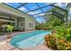 Screened-in pool area with brick pavers, mature landscaping, and a comfortable outdoor seating area at 14817 Tudor Chase Dr, Tampa, FL 33626