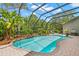 Backyard with a pool, water feature, tropical plants, screened enclosure and brick patio, perfect for outdoor relaxation at 14817 Tudor Chase Dr, Tampa, FL 33626