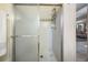 Modern bathroom featuring a shower with glass doors, neutral tile, and chrome fixtures at 15810 Stanton Ln, Tampa, FL 33647
