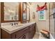 Bathroom boasts dual sinks, marble countertop, wood cabinets and a shower with glass doors at 15810 Stanton Ln, Tampa, FL 33647