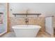 Freestanding soaking tub with tiled walls and a wood shelf at 15810 Stanton Ln, Tampa, FL 33647