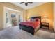 Comfortable bedroom featuring a bay window, carpet, warm colored walls, and bedside tables at 15810 Stanton Ln, Tampa, FL 33647