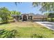 Attractive single-story home boasts a three-car garage and long driveway leading to an arched double door entrance at 15810 Stanton Ln, Tampa, FL 33647