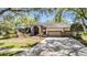 Attractive single-story home boasts a three-car garage and long driveway leading to an arched double door entrance at 15810 Stanton Ln, Tampa, FL 33647