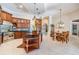 Open kitchen with wood cabinets, a kitchen island, stainless steel appliances, and dining area at 15810 Stanton Ln, Tampa, FL 33647