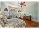 Large main bedroom featuring wood floors, exterior access and arched windows at 15810 Stanton Ln, Tampa, FL 33647