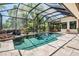 Beautiful pool area with screened-in enclosure, stone waterfall feature, and lush landscaping at 15810 Stanton Ln, Tampa, FL 33647