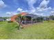 This backyard features a screened-in patio, manicured lawn, and an orange exterior that's perfect for outdoor entertaining at 1626 Brooksbend Dr, Wesley Chapel, FL 33543