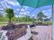 Enjoy outdoor living in this screened lanai with brick flooring, a grill, and peaceful views at 1626 Brooksbend Dr, Wesley Chapel, FL 33543