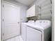 Laundry room with white washer and dryer, white cabinets, and wire shelving at 1626 Brooksbend Dr, Wesley Chapel, FL 33543