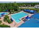 Aerial view of the community pool with lap lanes, lounge chairs, and blue sunshades at 1626 Brooksbend Dr, Wesley Chapel, FL 33543