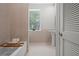 Bright bathroom with pedestal sink and large window over the tub at 17062 Comunidad De Avila, Lutz, FL 33548