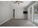 Bedroom features gray carpet, ceiling fan, a TV, and a balcony at 17062 Comunidad De Avila, Lutz, FL 33548