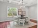 Elegant dining room with modern chandelier, oval table, seating for six, and views of the backyard at 17062 Comunidad De Avila, Lutz, FL 33548