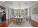 Formal dining room with hardwood floors, decorative fireplace, large windows, and a dining table set for ten at 17062 Comunidad De Avila, Lutz, FL 33548