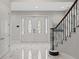 Bright foyer showcasing marble floors, staircase with wrought iron railing, and an elegant front door with glass inserts at 17062 Comunidad De Avila, Lutz, FL 33548