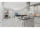 Bright kitchen with white cabinets, black countertops, stainless steel appliances, and a view to the living area at 17062 Comunidad De Avila, Lutz, FL 33548