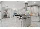 Bright kitchen with white cabinets, black countertops, stainless steel appliances, and a view to the living area at 17062 Comunidad De Avila, Lutz, FL 33548