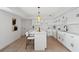 Modern white kitchen with quartz countertops, island seating, pendant lighting, and stainless steel sink at 17062 Comunidad De Avila, Lutz, FL 33548