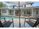 Inviting pool area with in-ground pool, brick patio, outside kitchen and white exterior of the home at 17062 Comunidad De Avila, Lutz, FL 33548