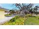Charming home exterior with lush landscaping, mature trees, and a winding driveway at 175 Bath Club N Blvd, North Redington Beach, FL 33708
