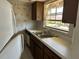 Functional kitchen with wood cabinets, sink, and view to the outdoors at 1845 S Highland Ave # 6-11, Largo, FL 33756