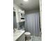 Cozy bathroom with a toilet, sink, cabinet and a patterned blue and white shower curtain at 18607 Bent Pine Dr, Hudson, FL 34667