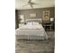Bedroom with wood-look flooring, white headboard, neutral walls, and decorative wall art at 18607 Bent Pine Dr, Hudson, FL 34667