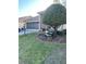 Charming home featuring a well-manicured lawn and decorative flower garden with a bench under a mature shade tree at 18607 Bent Pine Dr, Hudson, FL 34667