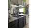 Well-lit kitchen area with granite countertops, black appliances, and dark cabinets at 18607 Bent Pine Dr, Hudson, FL 34667